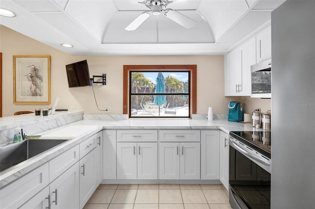 kitchen with sink, a tray ceiling, white cabinets, and appliances with stainless steel finishes