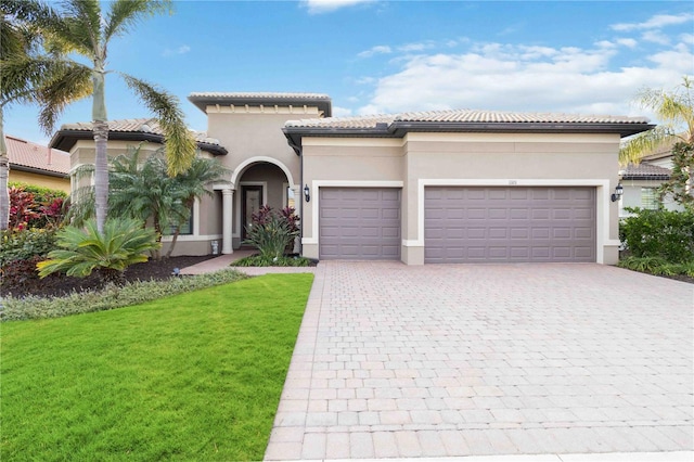 mediterranean / spanish-style house featuring a garage and a front lawn