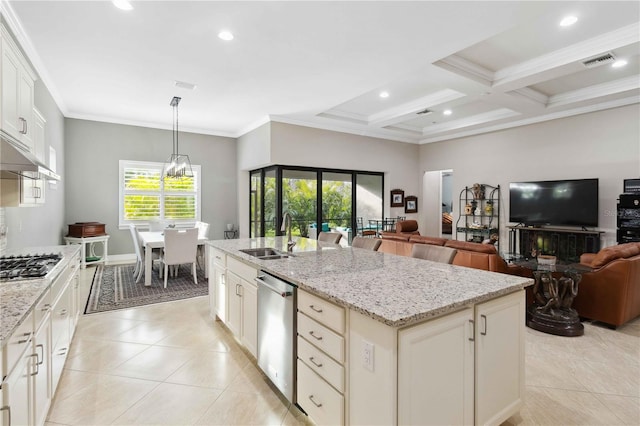 kitchen with light stone countertops, stainless steel appliances, sink, and a center island with sink