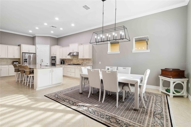 dining area featuring sink and ornamental molding