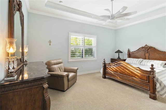 bedroom featuring light carpet, a tray ceiling, ornamental molding, and ceiling fan