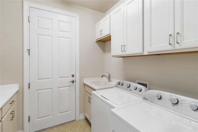 washroom featuring cabinets, washing machine and clothes dryer, and sink