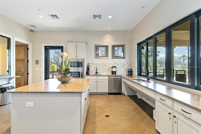 kitchen featuring light stone countertops, appliances with stainless steel finishes, sink, and white cabinets