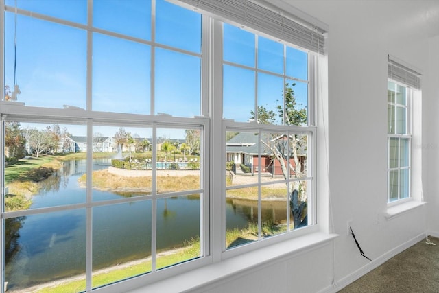 interior space featuring a water view and carpet floors