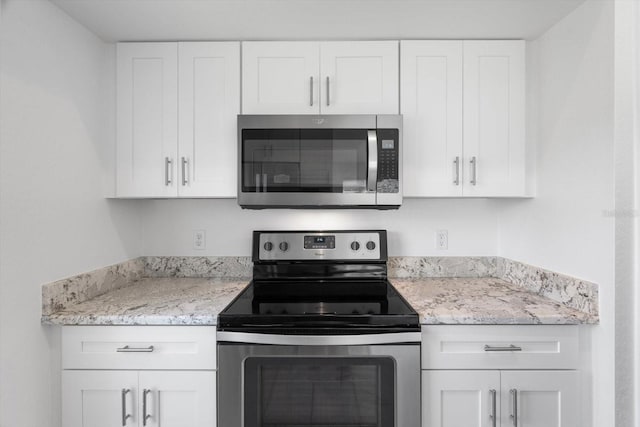 kitchen featuring appliances with stainless steel finishes, light stone countertops, and white cabinets