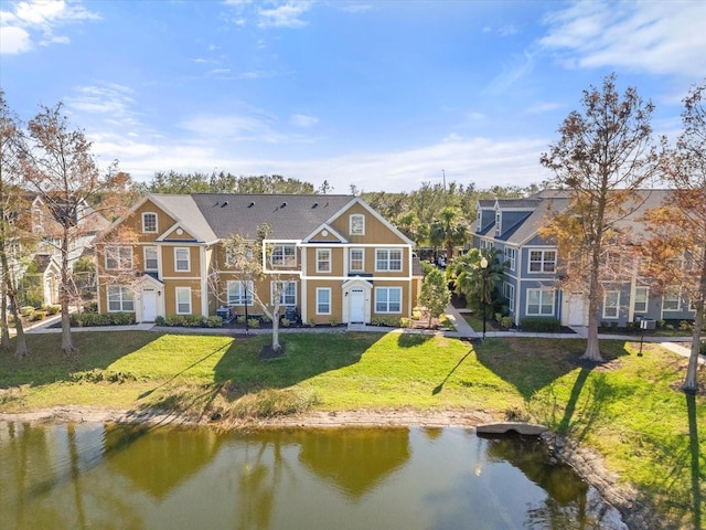 rear view of property with a water view and a yard