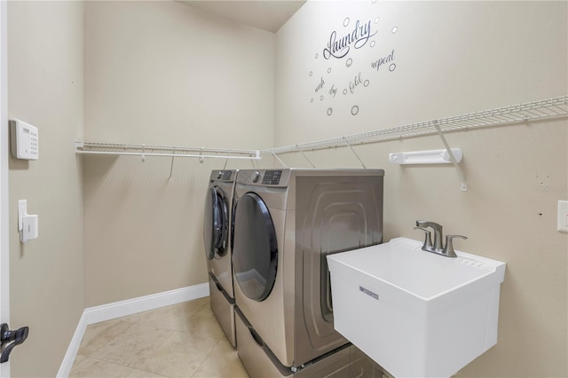 washroom with sink, light tile patterned floors, and washer and clothes dryer