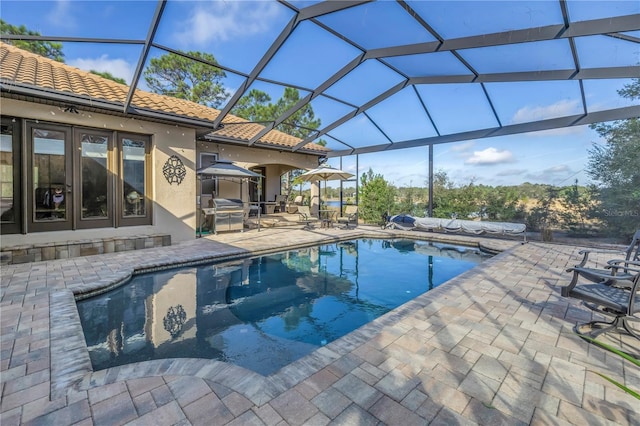 view of swimming pool featuring a patio, a grill, glass enclosure, and french doors