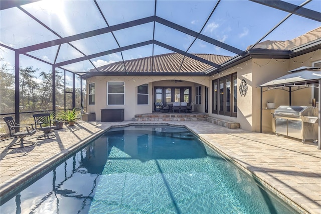 view of pool featuring ceiling fan, a lanai, area for grilling, and a patio area