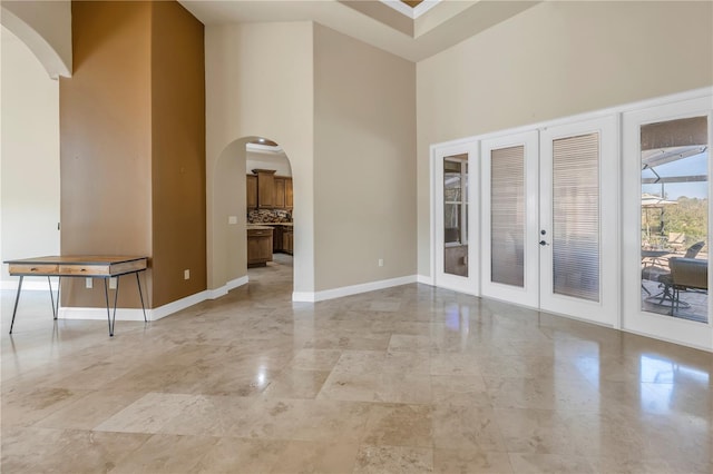 empty room featuring french doors and a high ceiling