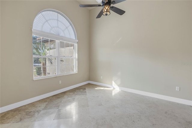 spare room featuring ceiling fan and a wealth of natural light