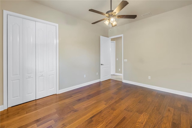 unfurnished bedroom featuring ceiling fan, wood-type flooring, and a closet