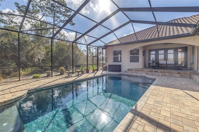 view of swimming pool featuring a patio area, ceiling fan, and glass enclosure