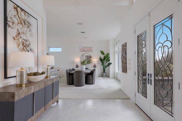 tiled foyer entrance featuring french doors and plenty of natural light