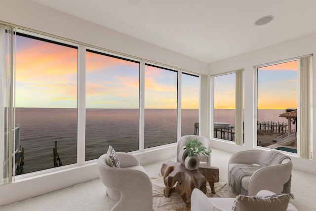 sunroom featuring a water view