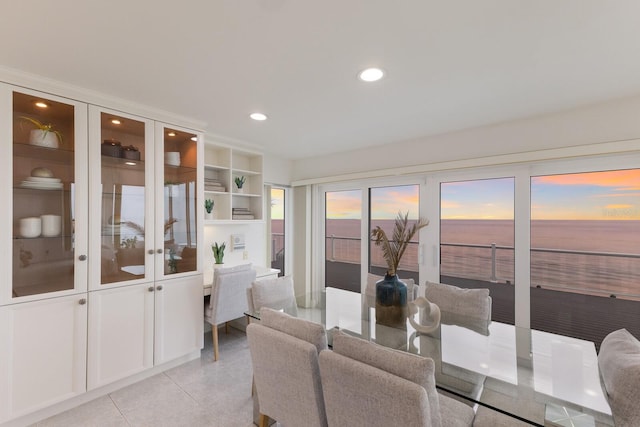 living room featuring light tile patterned floors and a water view