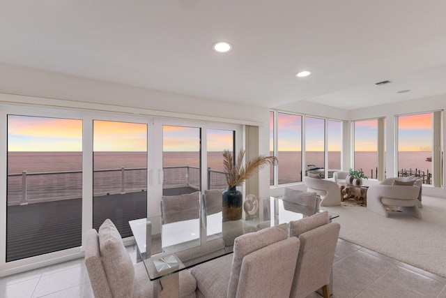 tiled dining room featuring a water view