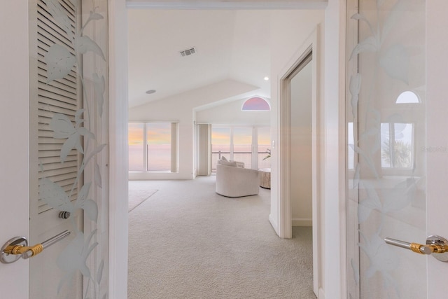 corridor with vaulted ceiling and carpet