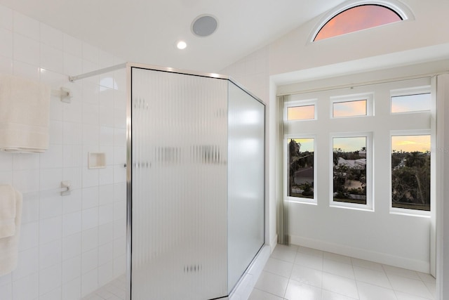 bathroom featuring tile patterned floors, a shower with shower door, and vaulted ceiling