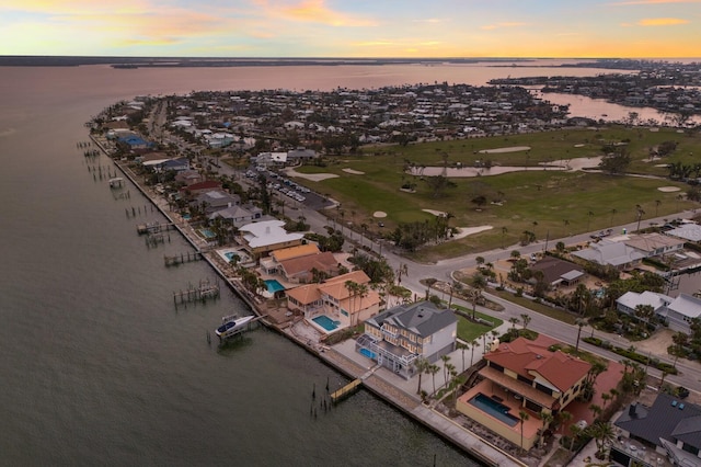 aerial view at dusk featuring a water view