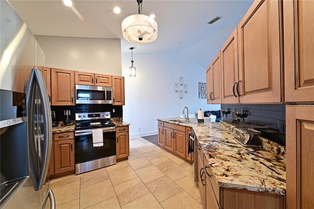 kitchen with appliances with stainless steel finishes, pendant lighting, lofted ceiling, decorative backsplash, and light stone countertops