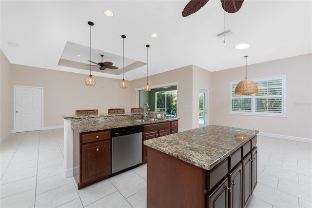 kitchen with sink, an island with sink, dishwasher, and stone countertops