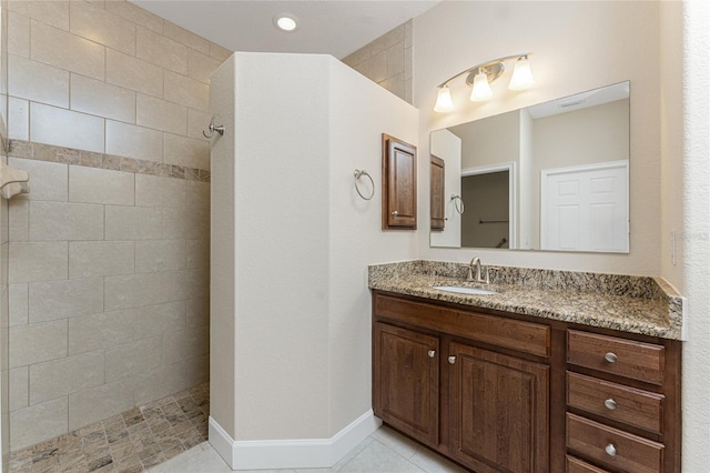 bathroom featuring tiled shower and vanity