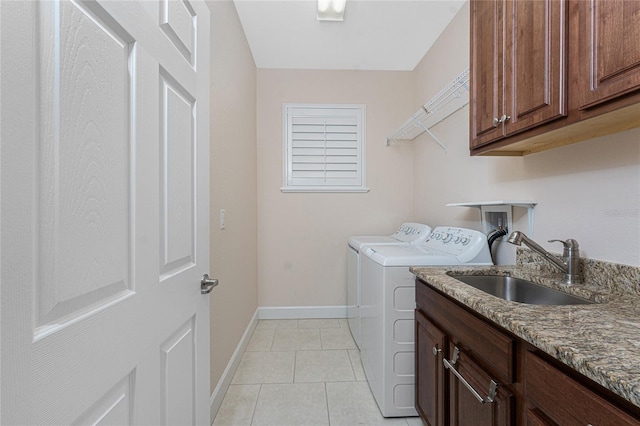 laundry area featuring washer and dryer, light tile patterned flooring, sink, and cabinets