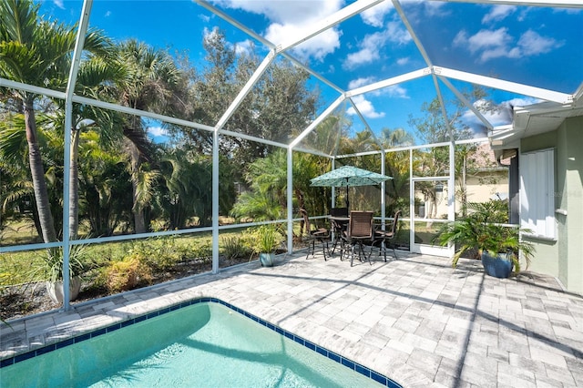 view of pool with a patio area and glass enclosure