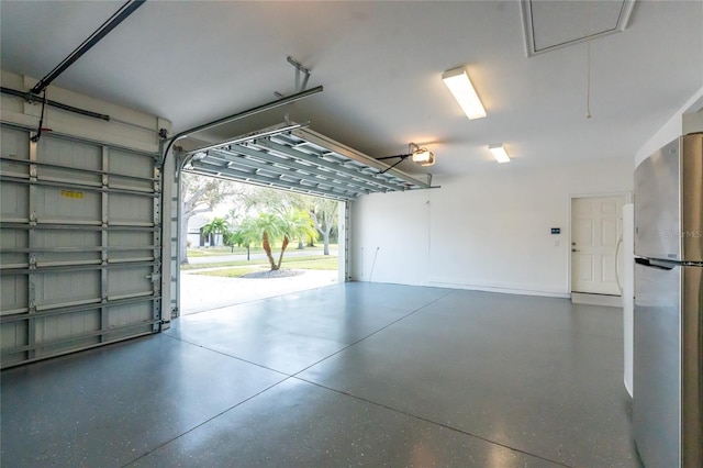 garage featuring a garage door opener and stainless steel refrigerator