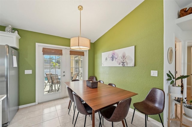 dining space with light tile patterned flooring, lofted ceiling, and french doors