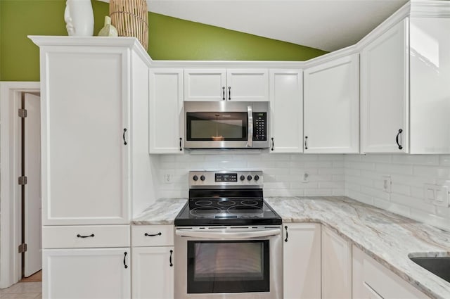 kitchen featuring white cabinetry, backsplash, vaulted ceiling, and stainless steel appliances