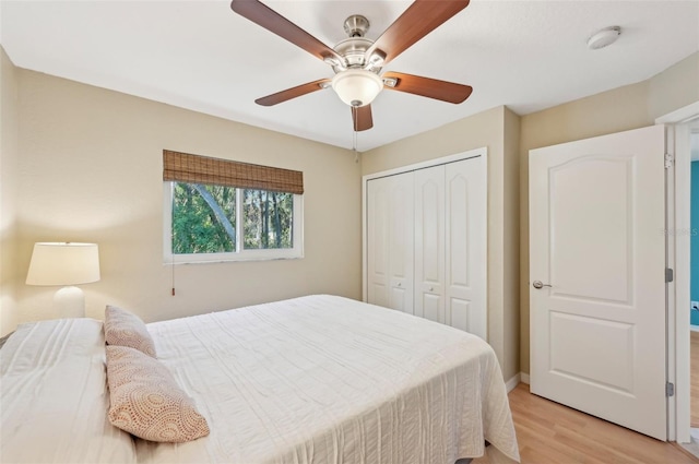 bedroom featuring light hardwood / wood-style floors, ceiling fan, and a closet