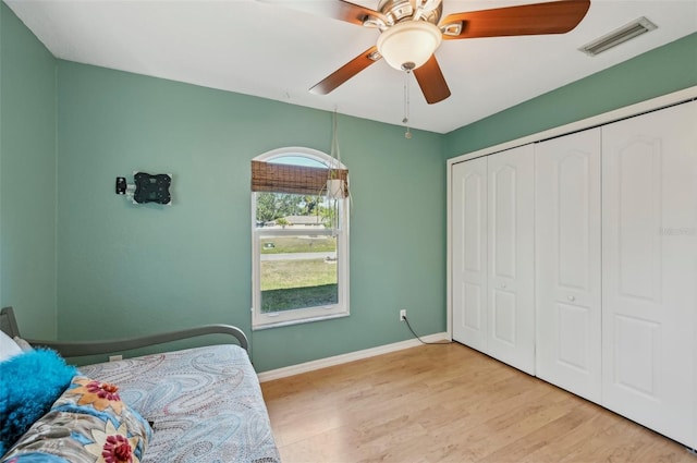 bedroom featuring ceiling fan, light hardwood / wood-style floors, and a closet