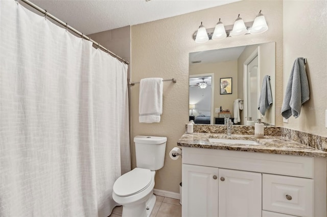 bathroom with ceiling fan, vanity, a textured ceiling, tile patterned floors, and toilet