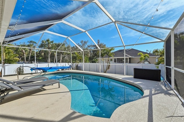 view of pool featuring glass enclosure and a patio area