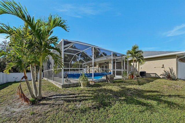 view of swimming pool with cooling unit, a yard, and glass enclosure