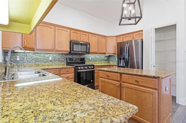 kitchen featuring appliances with stainless steel finishes, tasteful backsplash, sink, hanging light fixtures, and a center island