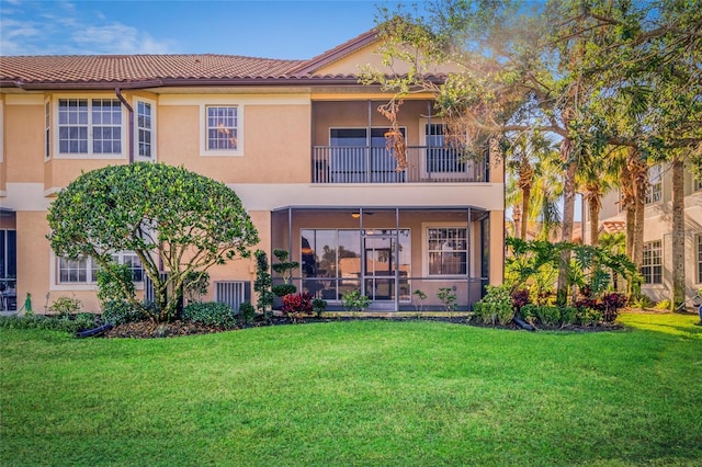 back of house featuring a balcony and a yard