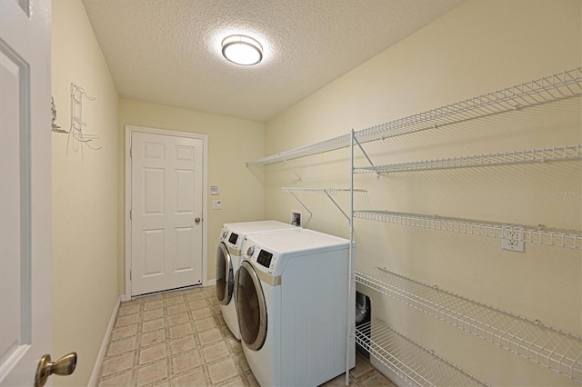 laundry area with a textured ceiling and washer and clothes dryer