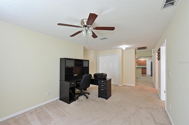 carpeted office with ceiling fan and a textured ceiling