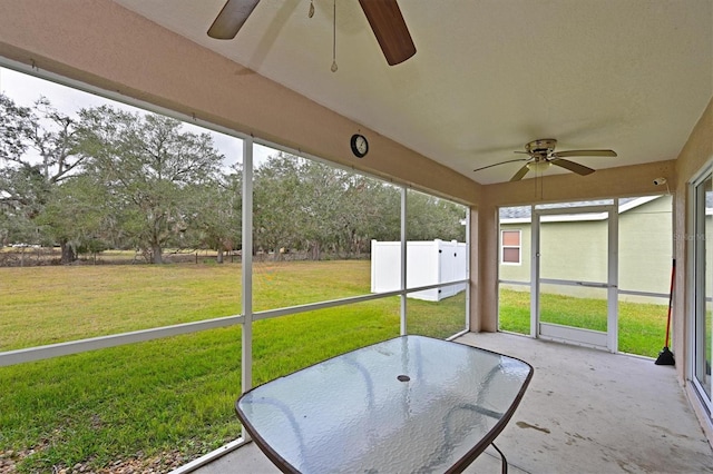 unfurnished sunroom with ceiling fan