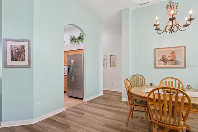 dining space with light hardwood / wood-style flooring and high vaulted ceiling