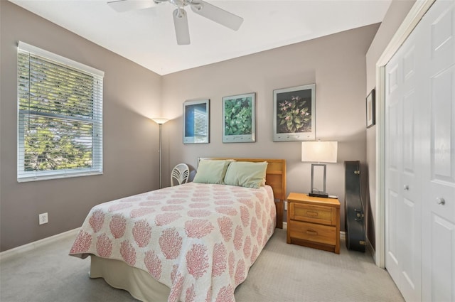 bedroom featuring light carpet, ceiling fan, and a closet