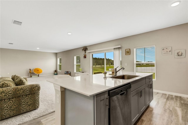 kitchen featuring sink, gray cabinetry, a center island with sink, stainless steel dishwasher, and light hardwood / wood-style floors