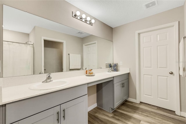 bathroom featuring vanity, hardwood / wood-style floors, and a textured ceiling