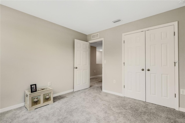 unfurnished bedroom with light carpet and a closet