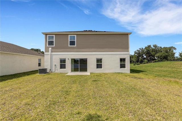 rear view of property with a yard and central AC