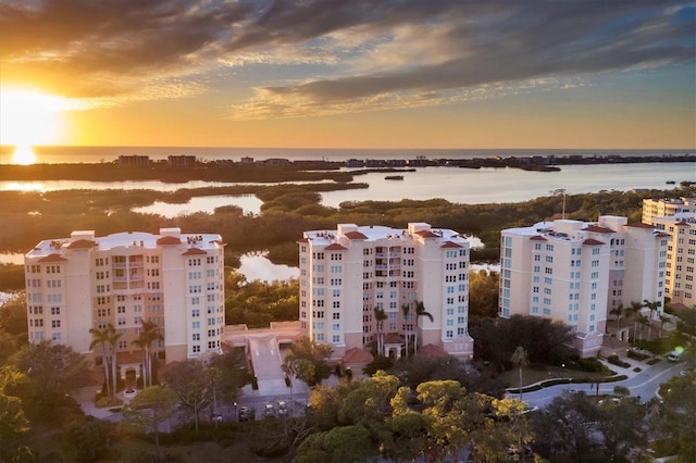 aerial view at dusk featuring a water view