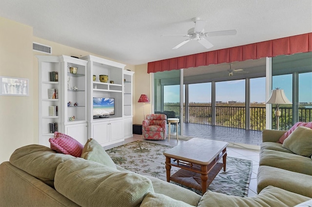 tiled living room featuring ceiling fan and a textured ceiling